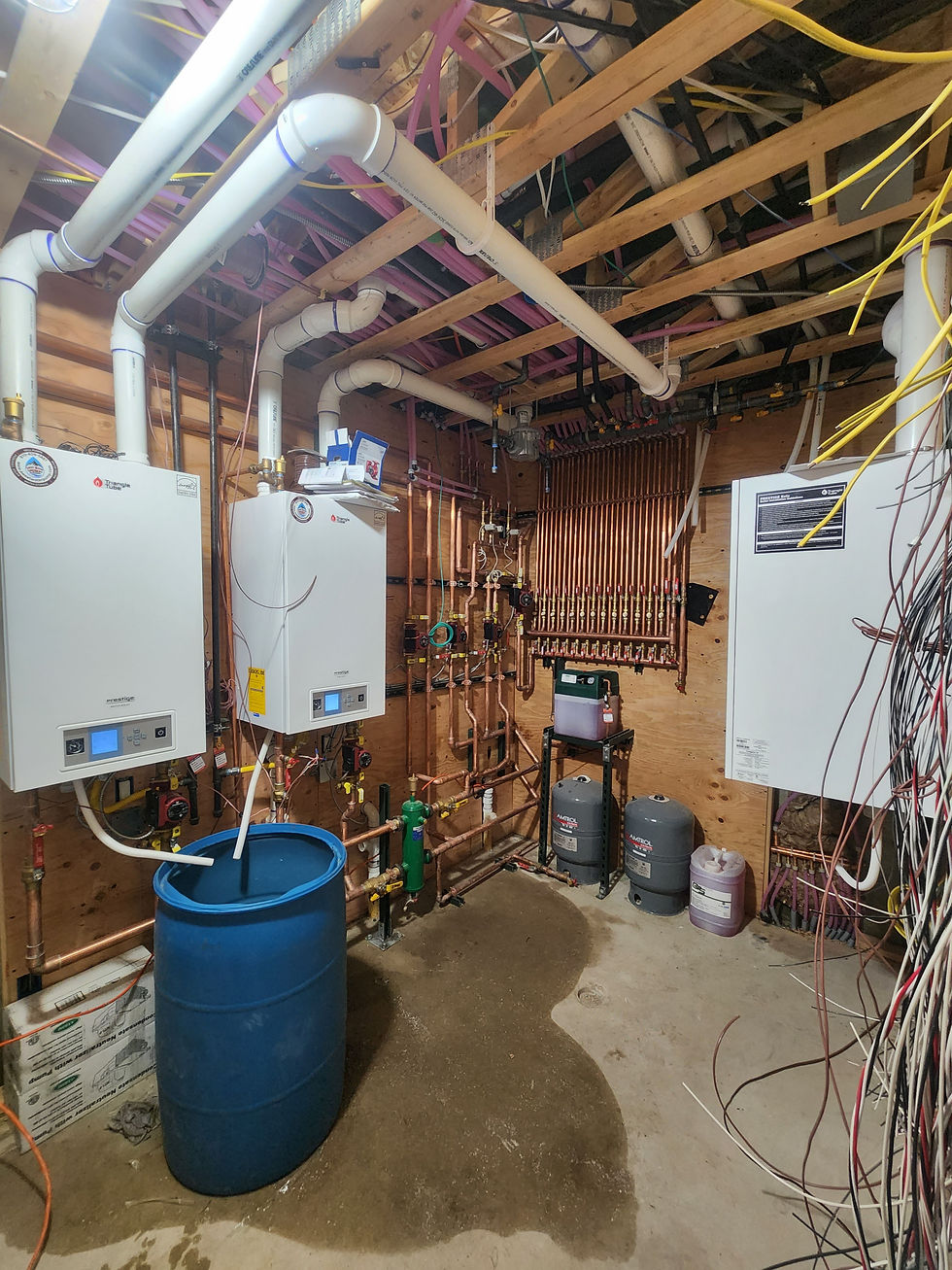 Two wall-hung boilers piped in an unfinished basement mechanical room