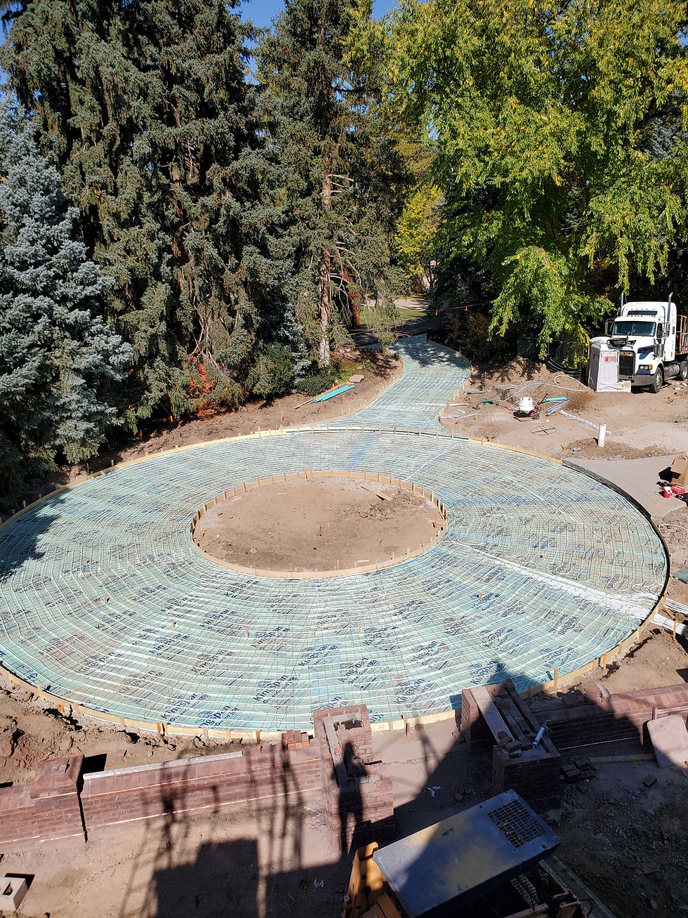 Circular patio snowmelt tubing laid over insulation before concrete