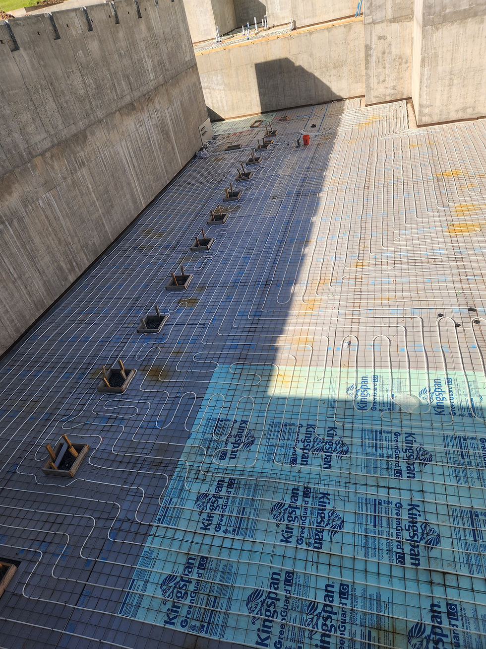 High-mass slab-on-grade radiant tubing tied to wire mesh over rigid foam before the concrete pour