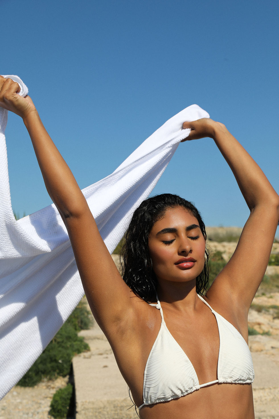 Model posing with beauty product and wearing makeup in Mallorca during a campaign shoot for a beauty product brand from Denmark.