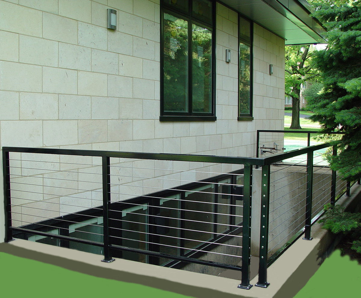 Modern exterior railing with metal posts and horizontal stainless-steel cables.