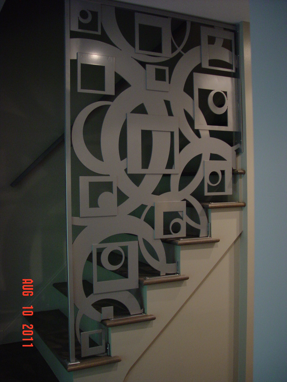 Sculptural interior metal screen with circles and open geometric shapes.