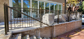 Ornate gold-tone metal fence with intricate scroll details
