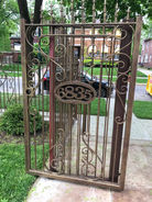 Elegant gold-tone wrought iron gate with ornate scrollwork.