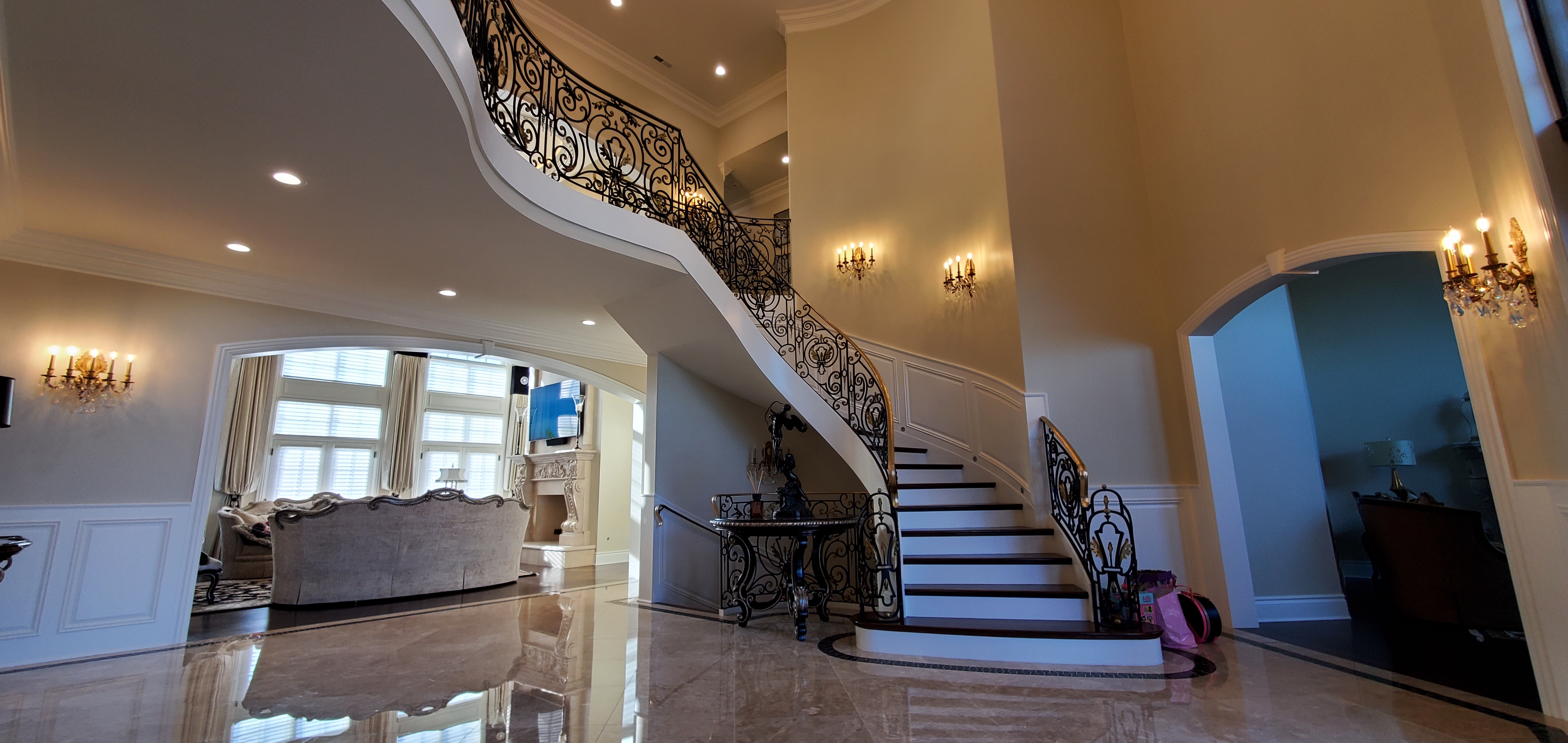 Ornate black scrollwork staircase railing with gold-toned handrail accents.