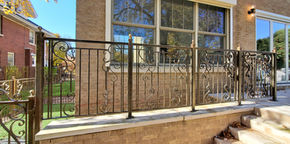 Ornate gold-tone metal fence with intricate scroll details.
