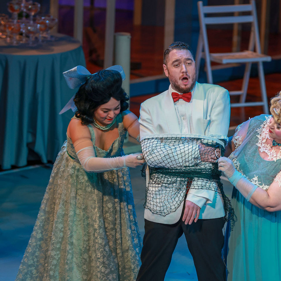 Opera singers performing a scene on stage.