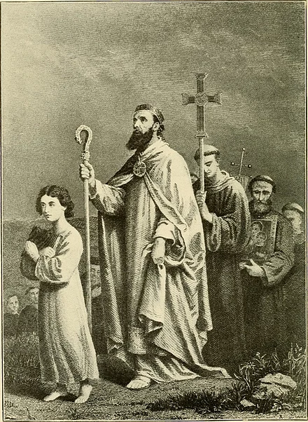Illustration of Saint Patrick walking barefoot toward Tara, dressed in flowing religious robes and holding a bishop's crozier. A young boy walks ahead of him, while monks carrying a cross and religious artifacts follow behind. The scene has a solemn and reverent atmosphere, with a crowd in the background. The image is from a 1904 book.
