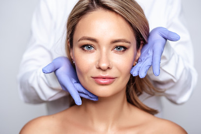 Smiling woman looking radiant and excited, preparing for a skin rejuvenation treatment.