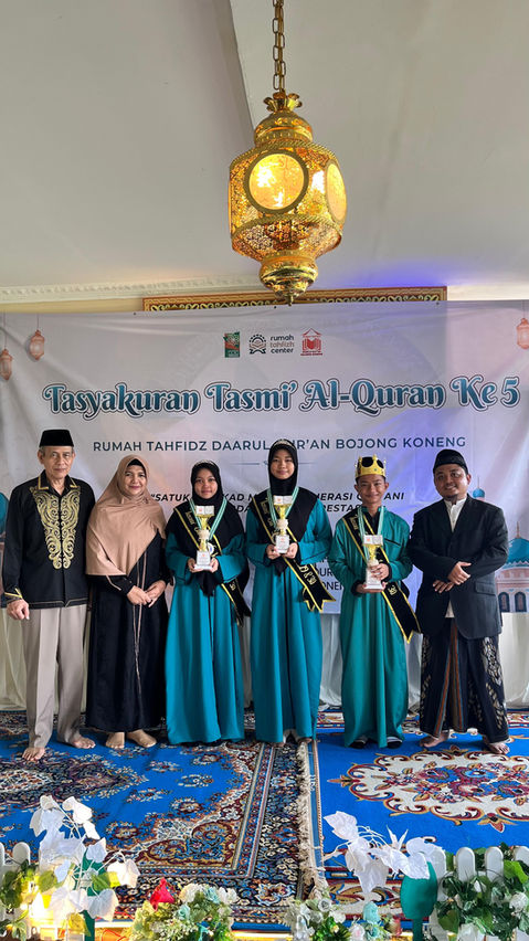 Santri dan santriwati Rumah Tahfidz Darul Qur’an Bojong Koneng berfoto bersama memegang piala usai tasyakuran tasmi’ Al-Qur’an.