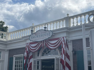 Colonial style building with a red and white striped banner. Above the banner sits a sign "Regal Eagle Smokehouse"