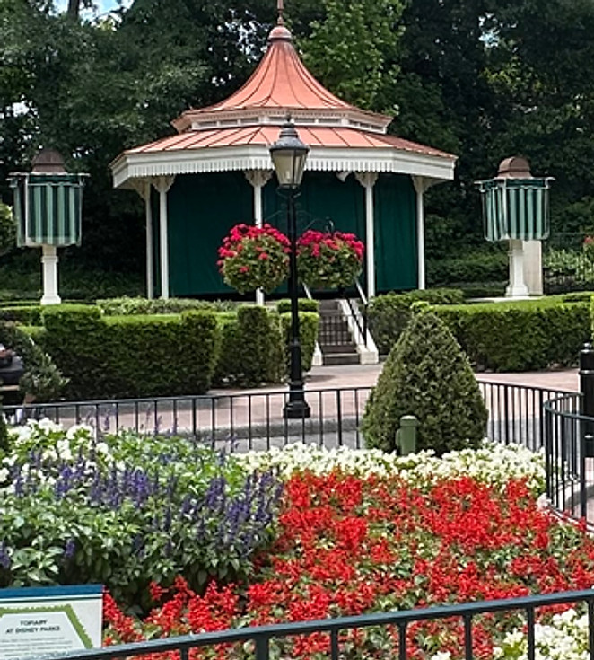 White Gazebo with hedges and pink flowers