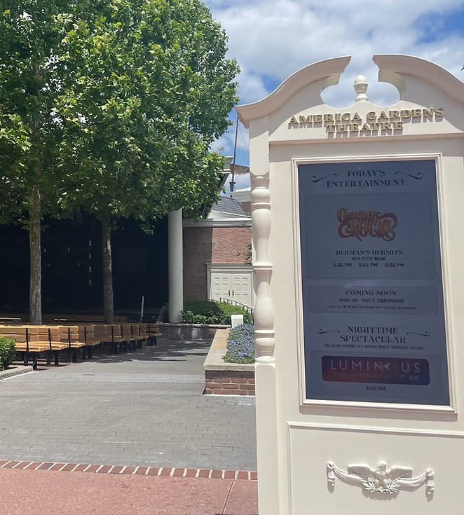 American Gardens Theater sign with theater and trees in the background