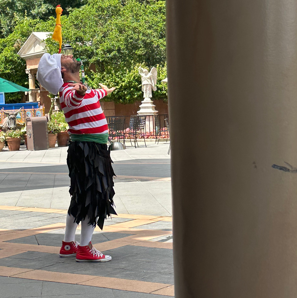 Sergio balancing an object on his forehead wearing a red and white striped shirt with trees in the background