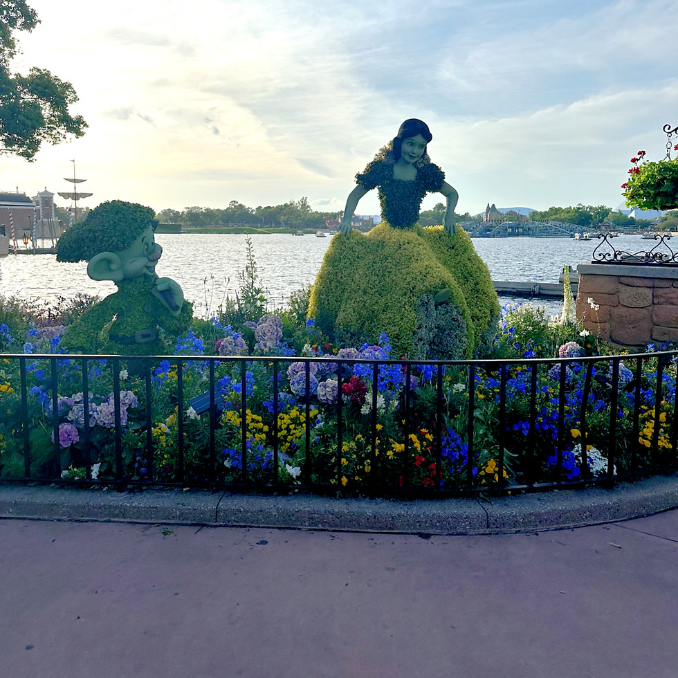 Snow White and Dopey Topiary infront of the lagoon.