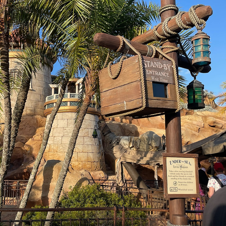 Entrance to Under the Sea – Journey of the Little Mermaid at Magic Kingdom, featuring a rocky seaside facade, and whimsical signage welcoming guests to Ariel’s world.