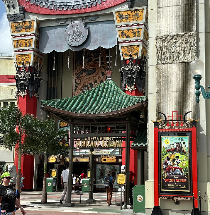 Iconic replica of Grauman’s Chinese Theatre with ornate red columns, dragon motifs, and a detailed façade, home to Mickey & Minnie’s Runaway Railway and projected animation after dark.