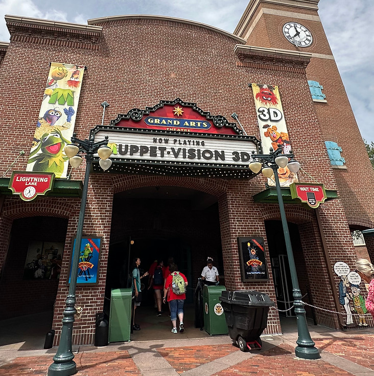 Brick theater-style entrance to MuppetVision 3D with a large arched sign reading “MuppetVision 3D."