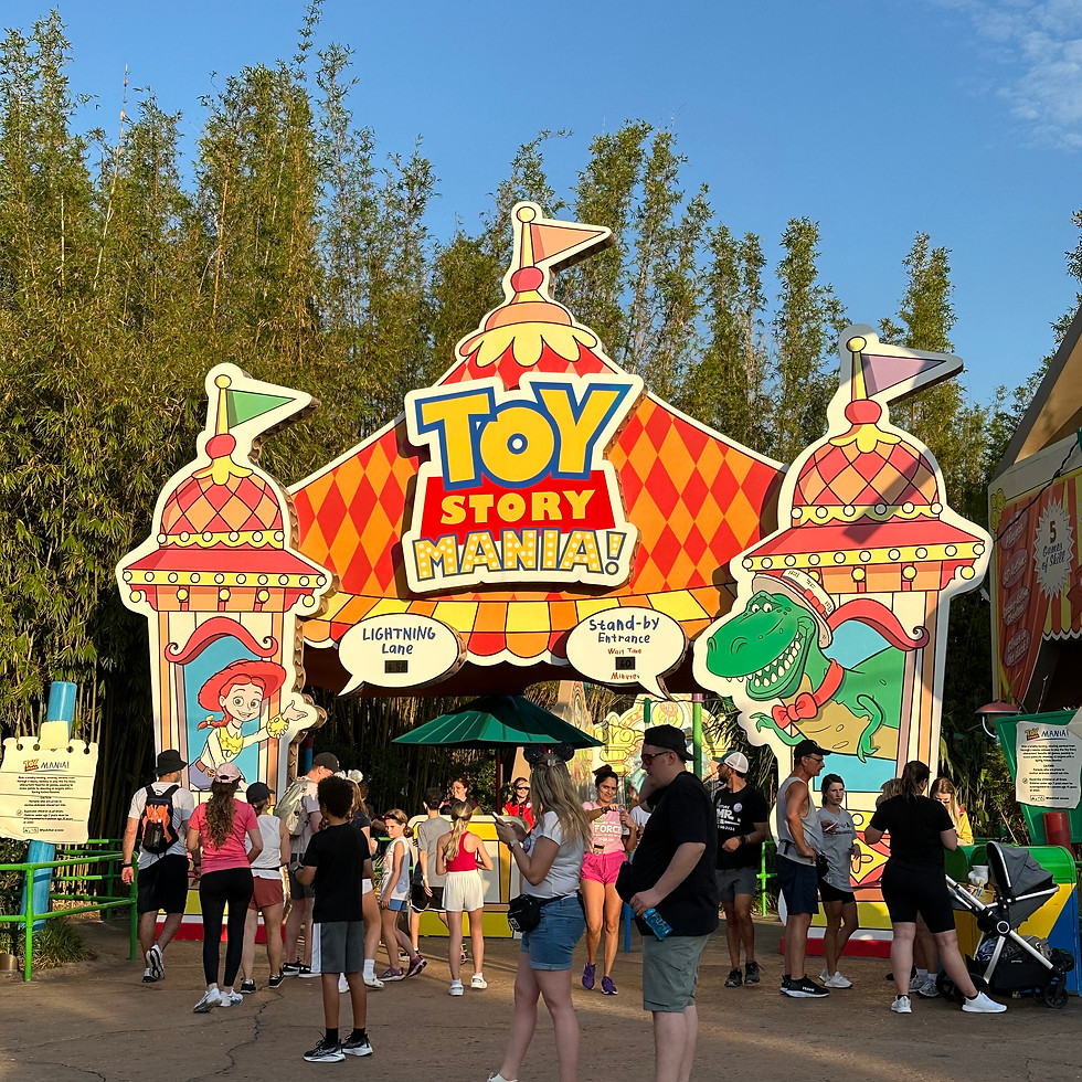 Toy Story Mania entrance made from oversized board game pieces and toys, with a colorful sign featuring Jessie and Rex.
