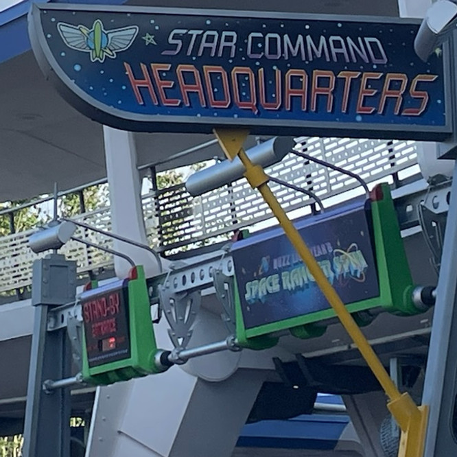 Buzz Lightyear’s Space Ranger Spin sign at Magic Kingdom, with vibrant neon colors, galactic lettering, and space-themed graphics welcoming guests to the interactive adventure.