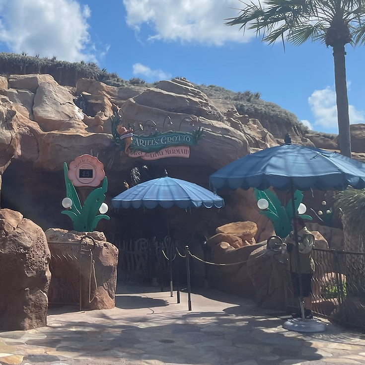 Ariel’s Grotto at Magic Kingdom, with under-the-sea decor, leading guests into a whimsical, ocean-themed cavern to meet Ariel in mermaid form.