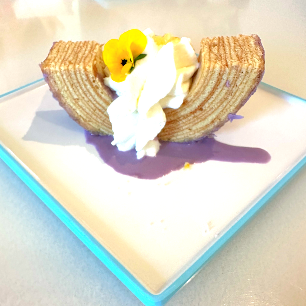 Lemon-Lavender Baumkuchen at EPCOT, a delicate layered cake with floral notes and citrus glaze, artfully sliced and plated.