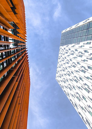 Blick nach oben auf moderne Gebäude, rostfarben und weiß.