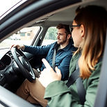 A driving instructor teaching someone to drive inside a car.jpg