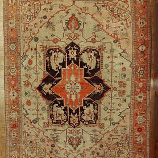 A magnificent antique Persian Serapi, which is just a very early Heriz rug, 11-9x15-3. This rug is very unusual because of the simple motif and not a lot of pattern. It has a light ivory background with salmon-colored corners and a rust border. Spectacular rug!