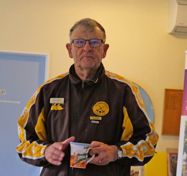 Man in brown and yellow jacket holding a card