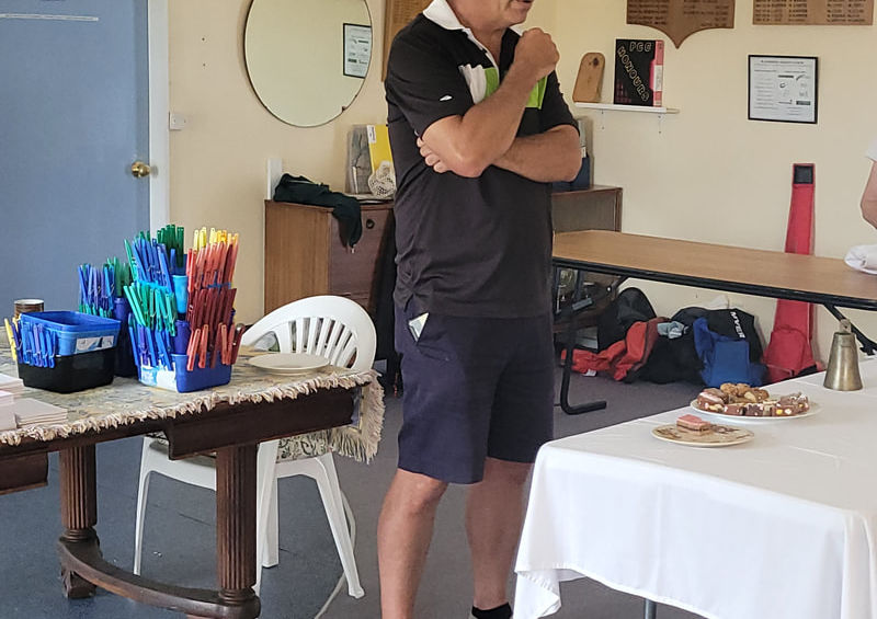 Man in black shirt and cap observing at an indoor event
