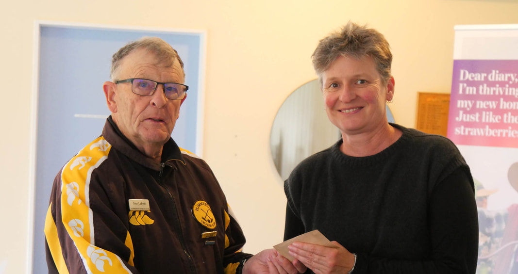 Man in club jacket shaking hands with woman receiving award