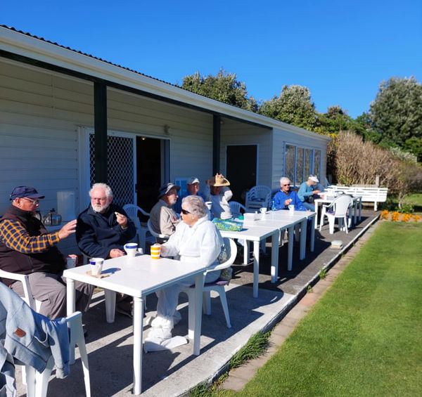 Group of people socializing at outdoor tables on a sunny day