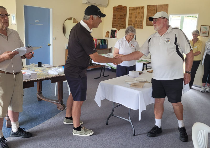 Two men shaking hands at an indoor event