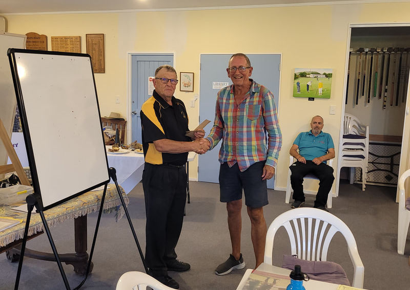 Two men shaking hands at an indoor event