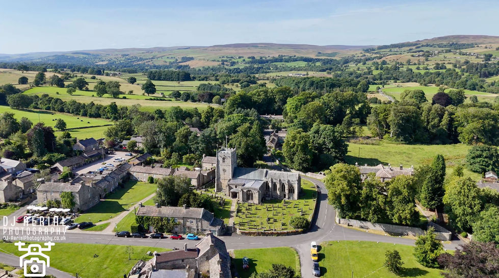 an aerial view of a small village with a church in the middle