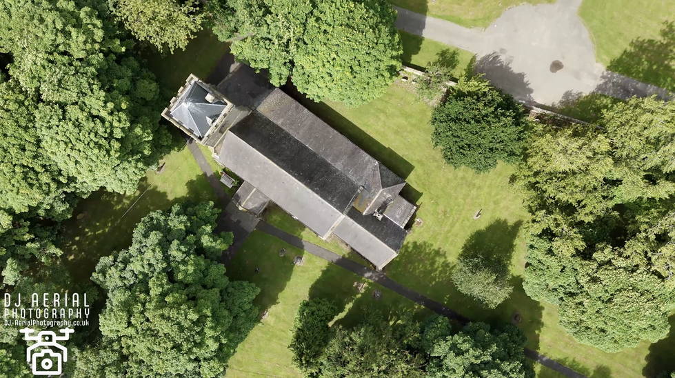 an aerial view of a church surrounded by trees