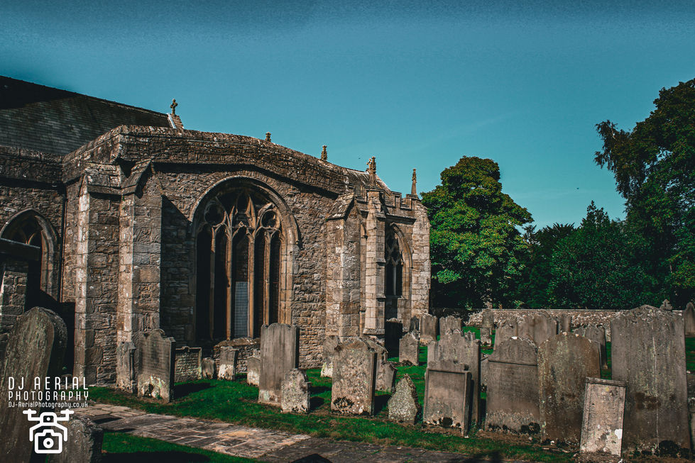 a cemetery with a stone building in the background