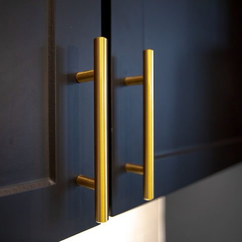 Sleek black cabinets with gold hardware in the kitchen