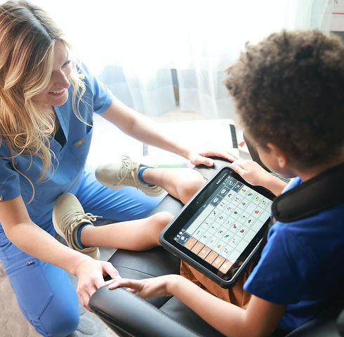 Child using a high-tech communication device during AAC therapy