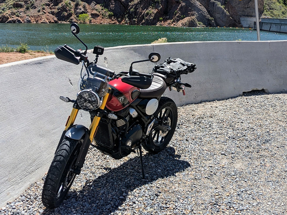 A red motorcycle parked alongside a lake