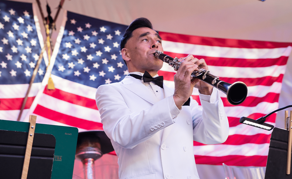 A concert oboist performing in front of an American flag