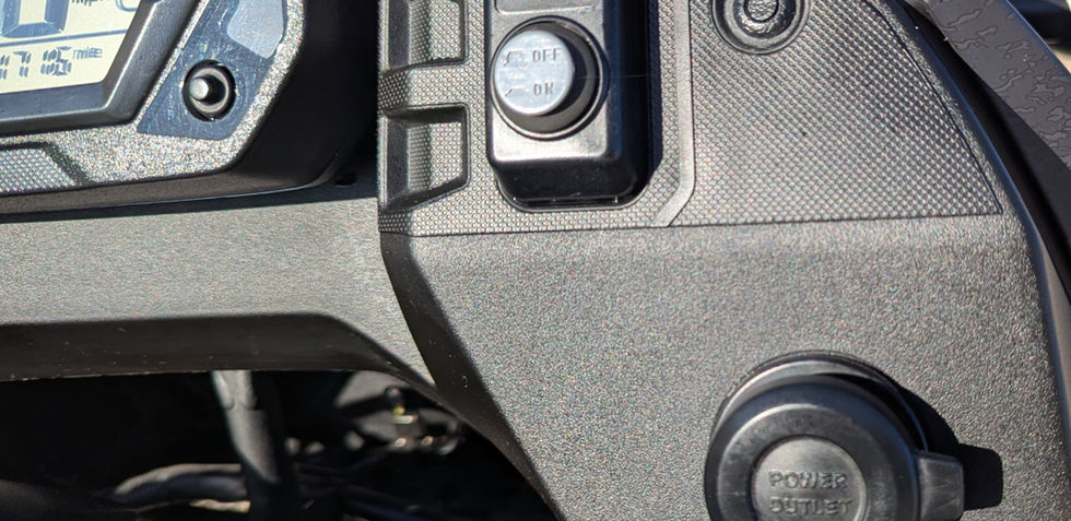 Closeup of a 12V charge port on a motorcycle