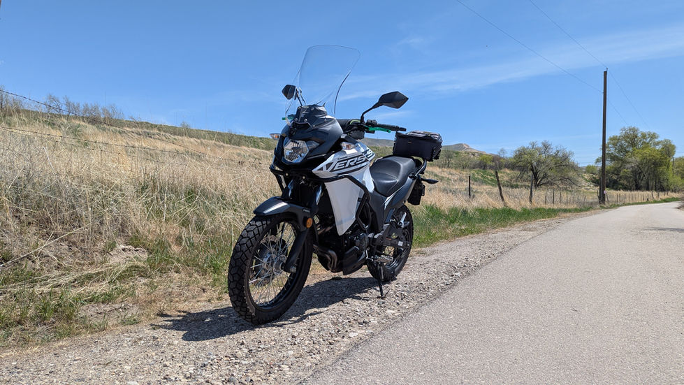 A white motorcycle parked alongside a road