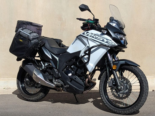 A white motorcycle parked in front of a wall