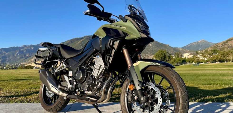 A green motorcycle parked in front of a mountain