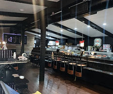 Image of the inside of the I Love Sushi restaurant. Point of view is from the front door facing the left side of restaurant where the sushi bar is visible.