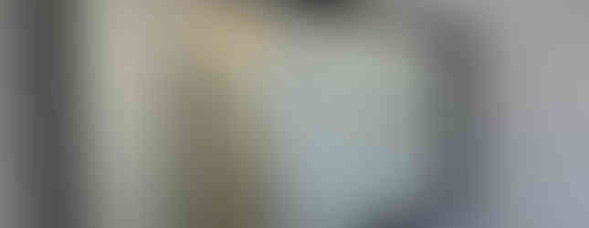 bathroom with white walls and countertop, black framed mirror, black hardware and gray vanity