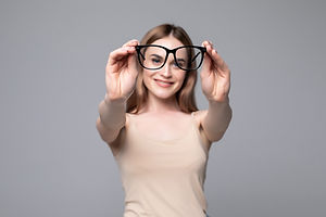 glasses-optician-showing-eyewear-closeup-glasses-with-glasses-frame-focus-woman-gray-wall.