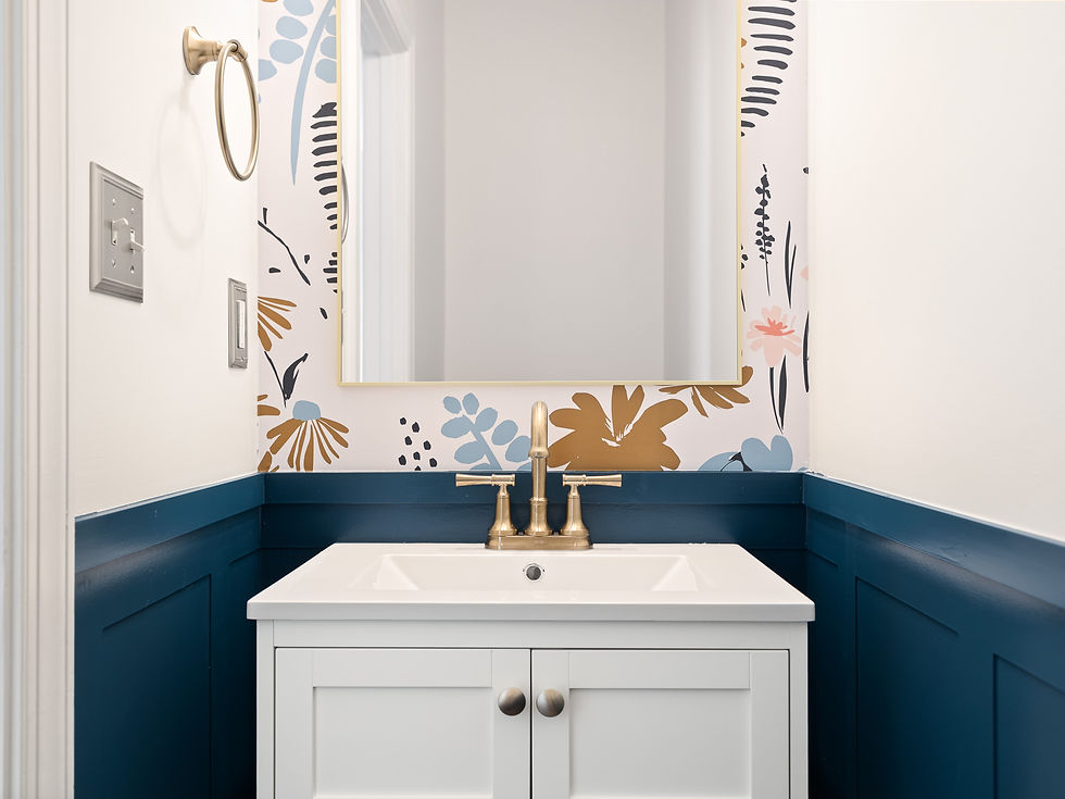 A powder room with accent wallpaper and teal wall paneling.